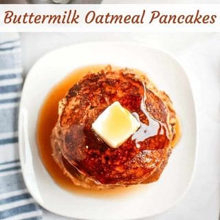 A stack of buttermilk oatmeal pancakes topped with a pat of butter and syrup on a white plate.