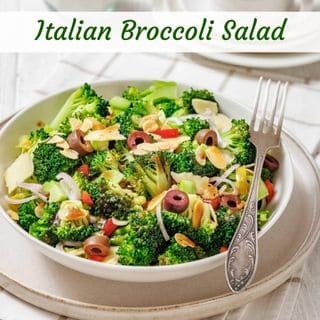 A bowl of Italian broccoli salad with broccoli florets, sliced olives, red onions, red peppers, and almond slivers, served with a fork. The text "Italian Broccoli Salad" is at the top.