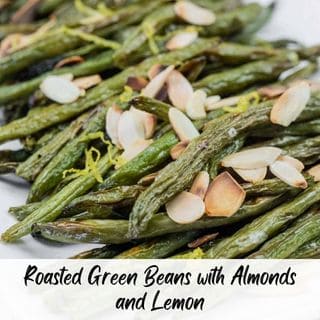 A plate of roasted green beans topped with sliced almonds and lemon zest.