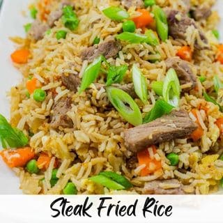 A close-up of a plate of Steak Fried Rice garnished with green onions.