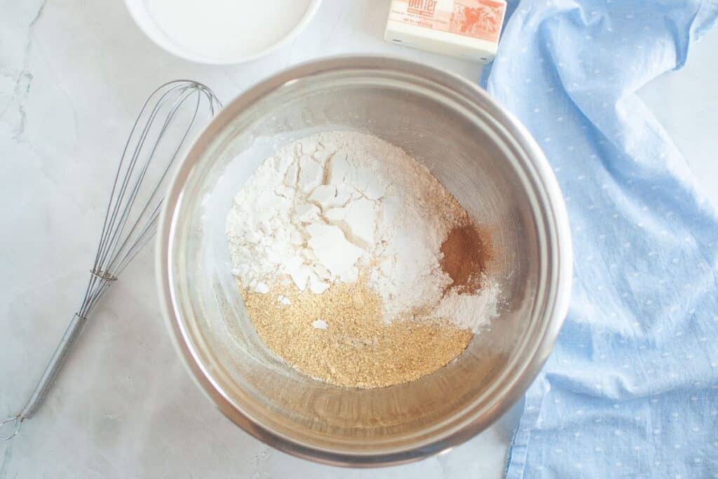 Preparing together the flour, graham cracker crumbs, baking powder, salt, and cinnamon in a large mixing bowl.