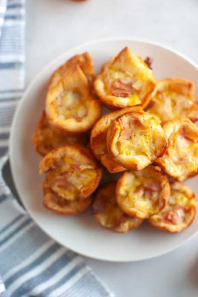 Overhead shot of a plate of small, golden-brown Ham & Cheese Puffs.