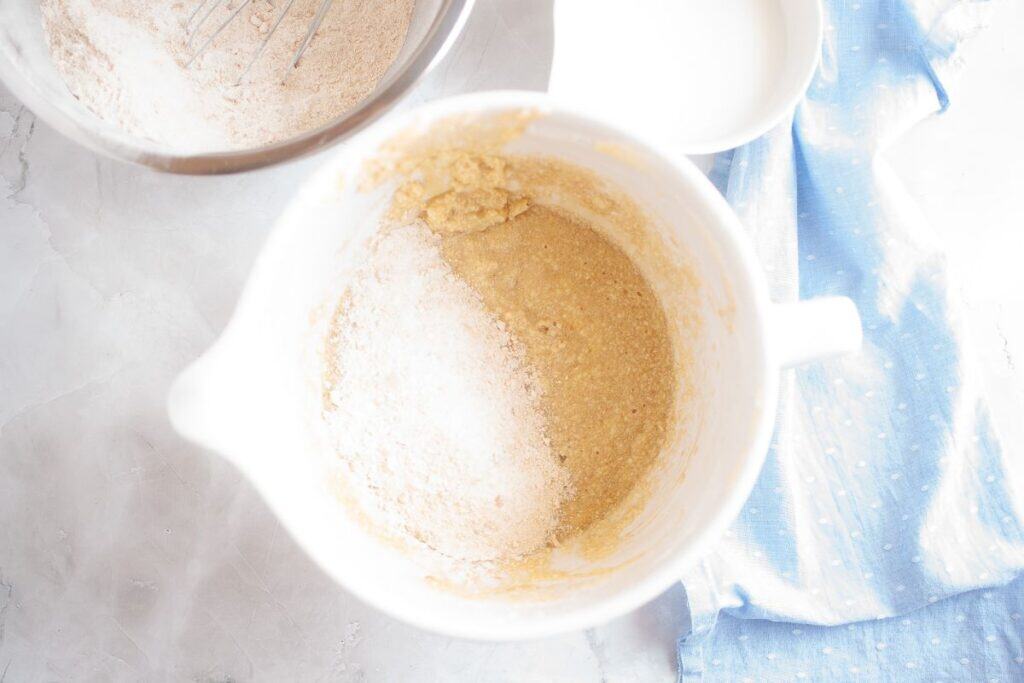 Adding dry ingredients to the mixture.