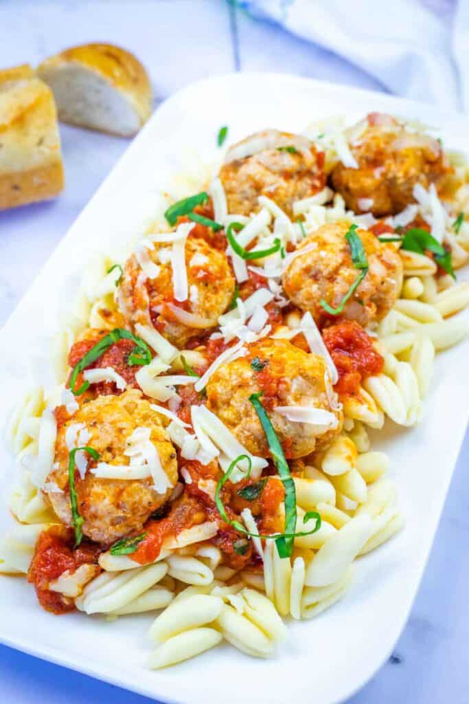 A white plate with Chicken Parmesan meatballs.
