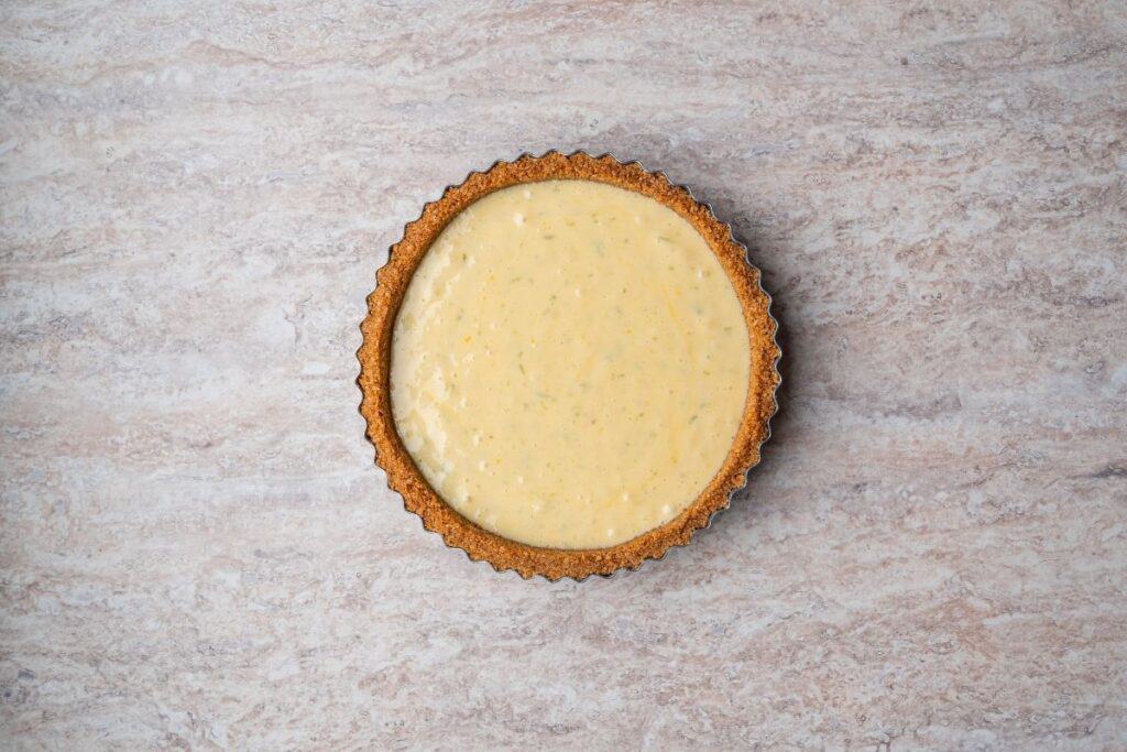 Adding the mixture to the pan and smoothing the top for Creamy Key Lime Pie.