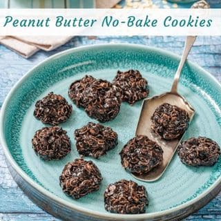 A plate with eight chocolate peanut butter no-bake cookies, one cookie on a metal spatula, displayed on a blue wooden table.