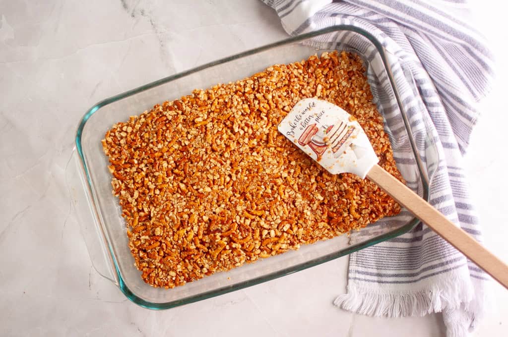 Pressing down firmly to create a solid crust.