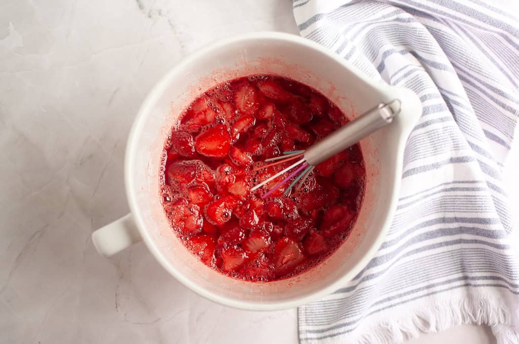 Stir the strawberry gelatin into the boiling water in a bowl and add the berries.