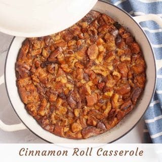 An overhead shot of a warm cinnamon roll casserole in a round white baking dish with a partial lid, showing golden-brown, caramelized pieces of cinnamon roll. The text "Cinnamon Roll Casserole" is overlaid at the bottom.