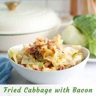 A white bowl filled with cooked cabbage and bacon sits on a counter with a head of cabbage and a pot in the background. Text reads "Fried Cabbage with Bacon.