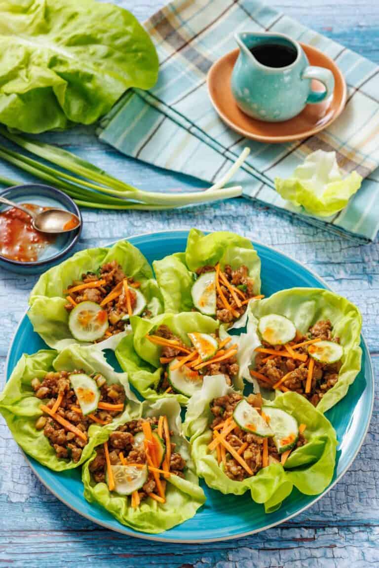 Ingredients for a lettuce wrap on a white surface.