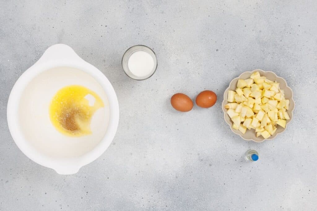 Whisked eggs, milk, and ingredients for cooking or baking on a kitchen countertop.