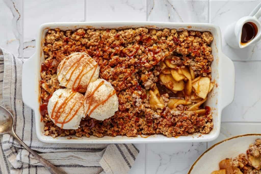 Golden apple crisp with vanilla ice cream and caramel drizzle. Perfect dessert for fall and family gatherings.