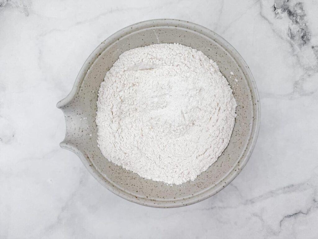 White powdered supplement in ceramic bowl for health support and detox.