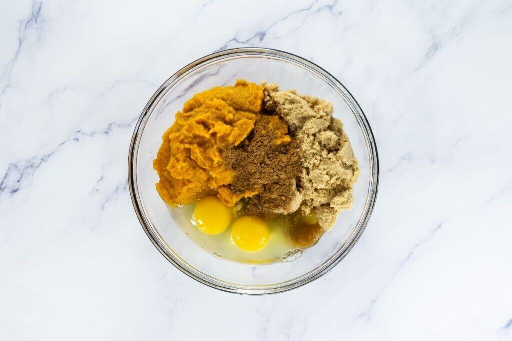 In a medium bowl, whisk pumpkin puree, brown sugar, pumpkin pie spice, and the 2 eggs until smooth.