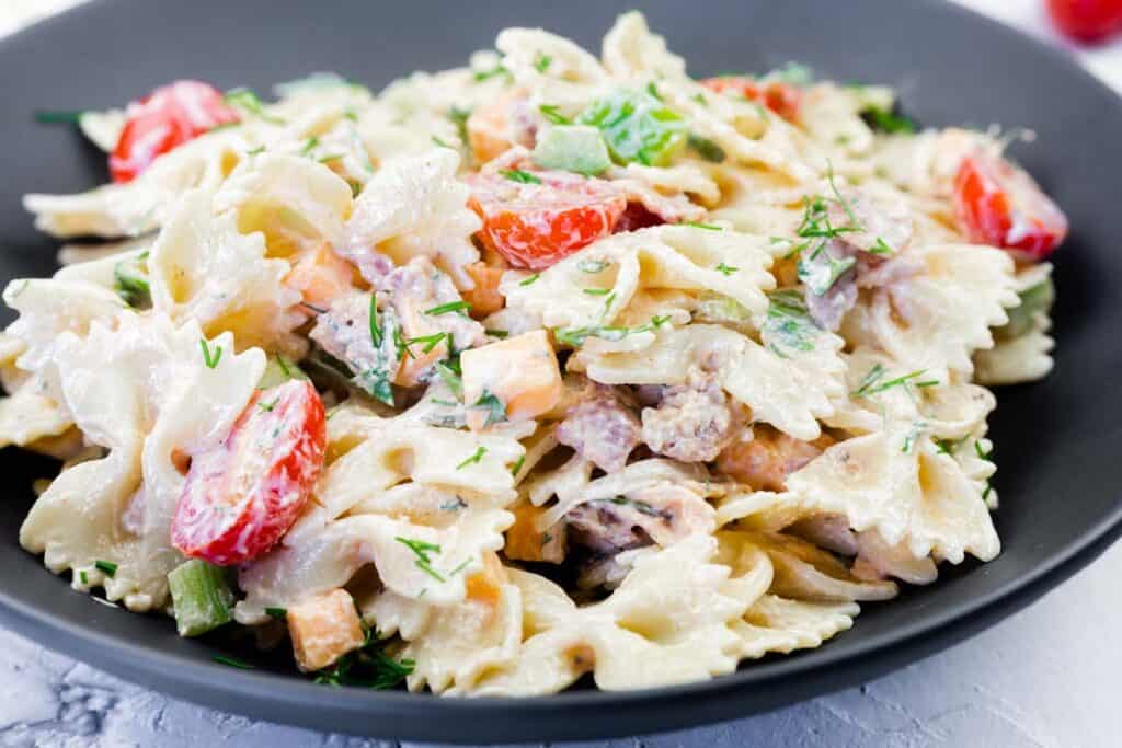 Close up photo of Classic Bacon Pasta Salad on a black plate.