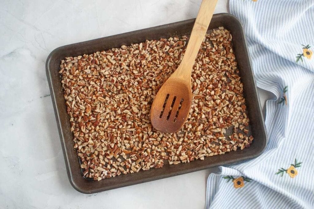 Toasted chopped pecans on a tray.