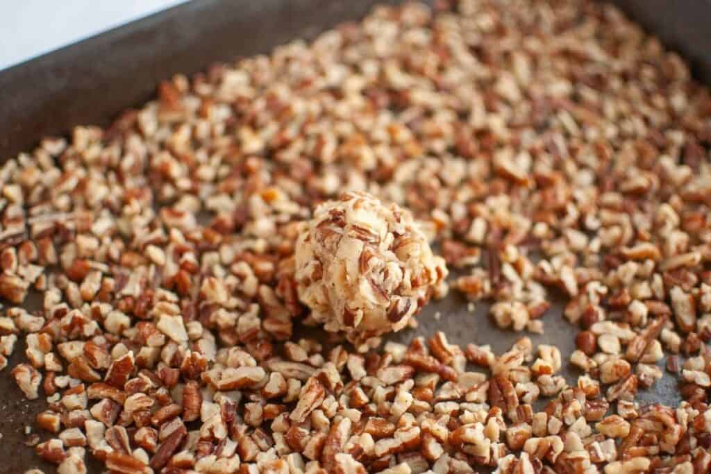 Roll each dough ball in the toasted chopped pecans, pressing gently so they stick.