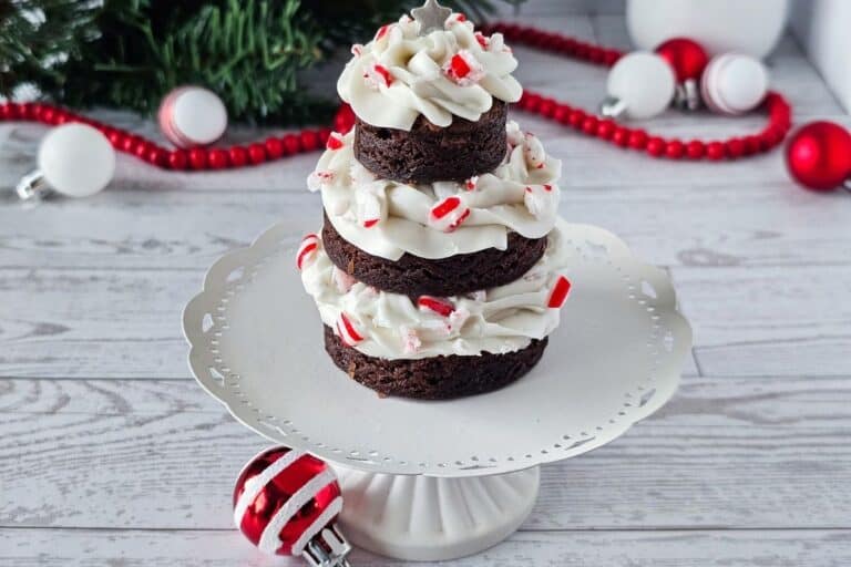 Chocolate peppermint cupcakes with white frosting and peppermint sprinkles on a decorative cake stand, holiday Christmas dessert.