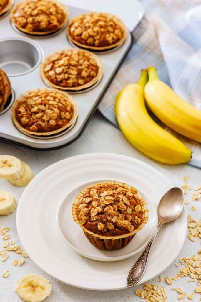 Buttercup muffins with oats and bananas on a plate and baking tray, healthy breakfast options, easy muffin recipe, wholesome baked goods, thebiteStuff.