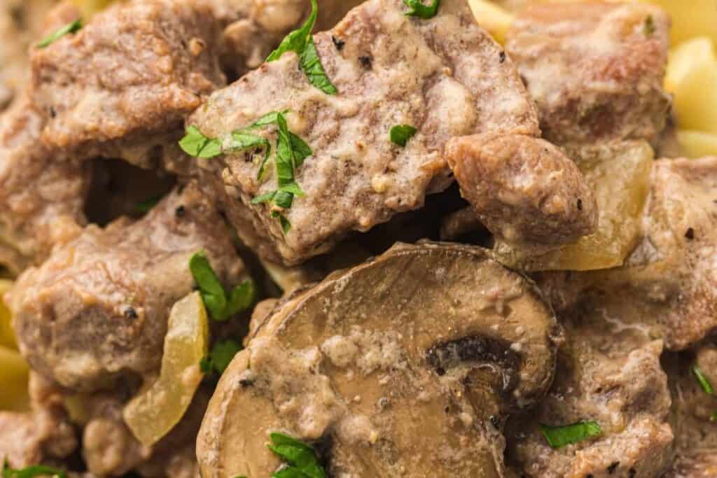 Close-up of delicious beef stroganoff featuring tender beef chunks, mushrooms, and herbs for a hearty meal.