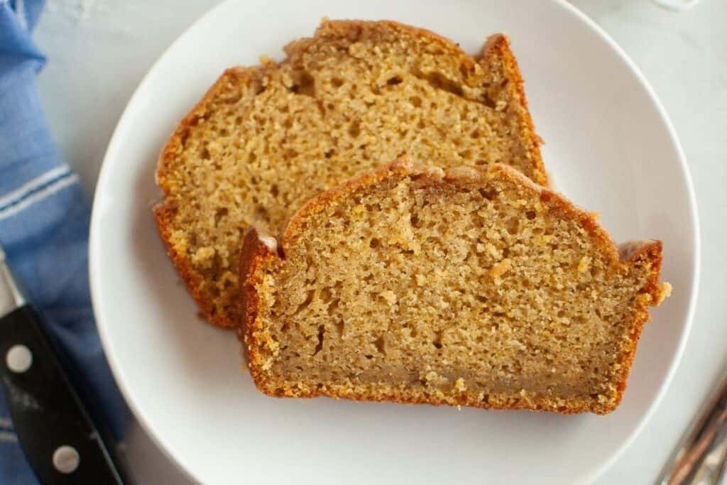 Two slices of Butternut Squash Loaf with Spiced Icing on a white plate.
