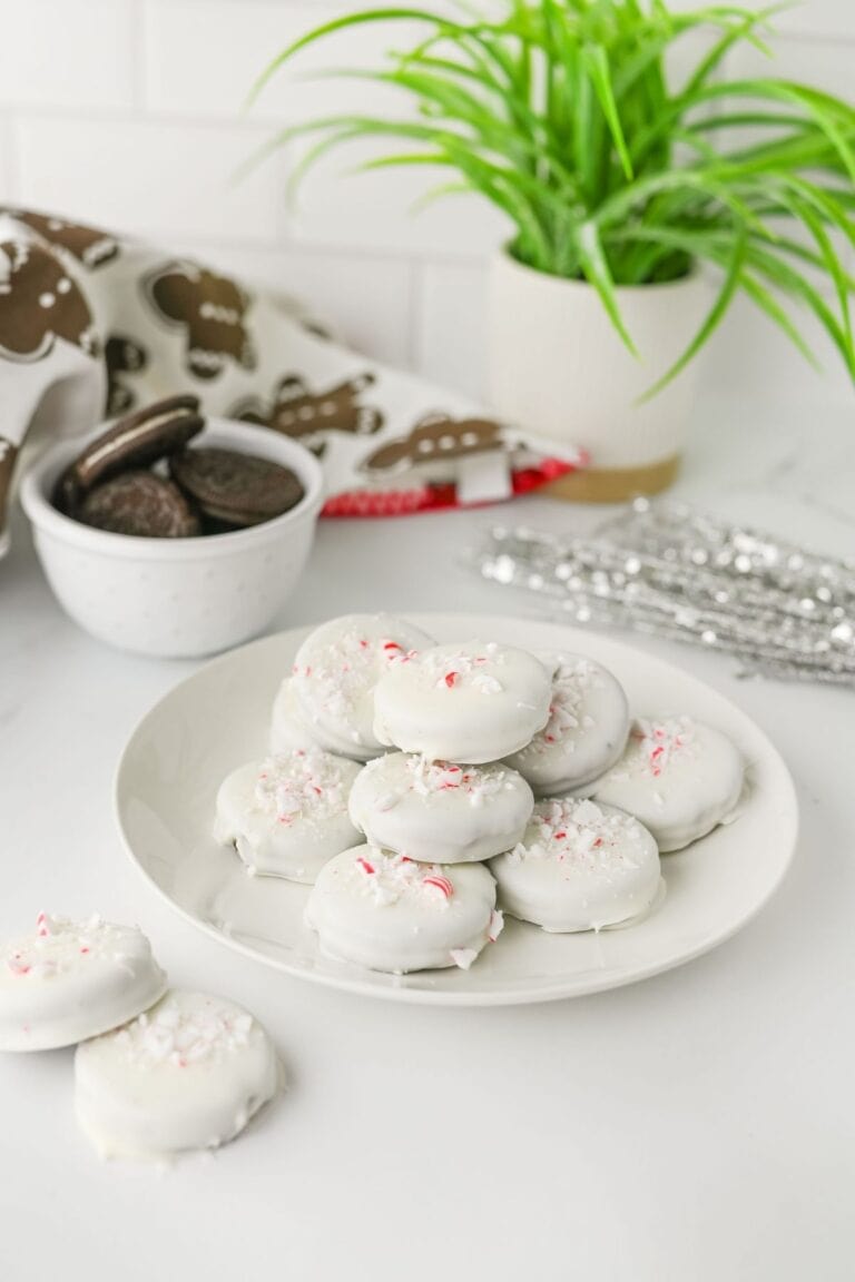 A round white plate with a pile of Peppermint Crunch Oreo.