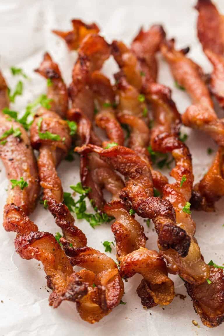 Crunchy twisted bacon garnished with crisp green leaves, adding freshness to every bite.