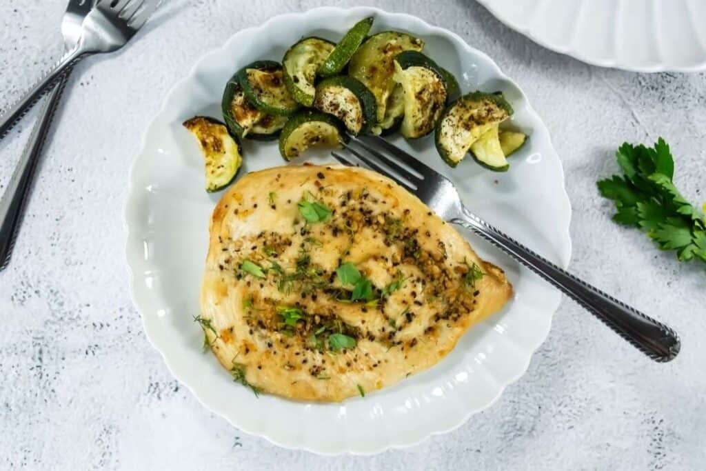 Delicious grilled chicken with lemon, herbs, and black pepper served with roasted zucchini.