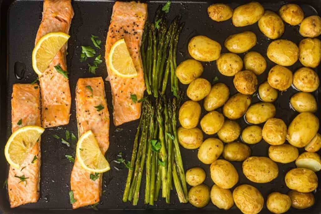 A vibrant sheet-pan dinner with flaky salmon, tender asparagus, and golden roasted potatoes, finished with fresh lemon for a bright, savory touch.