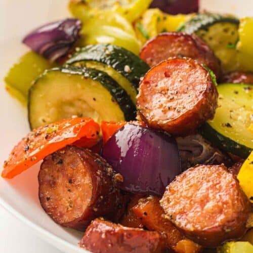 A white bowl filled with Sheet Pan Sausage & Roasted Vegetables.