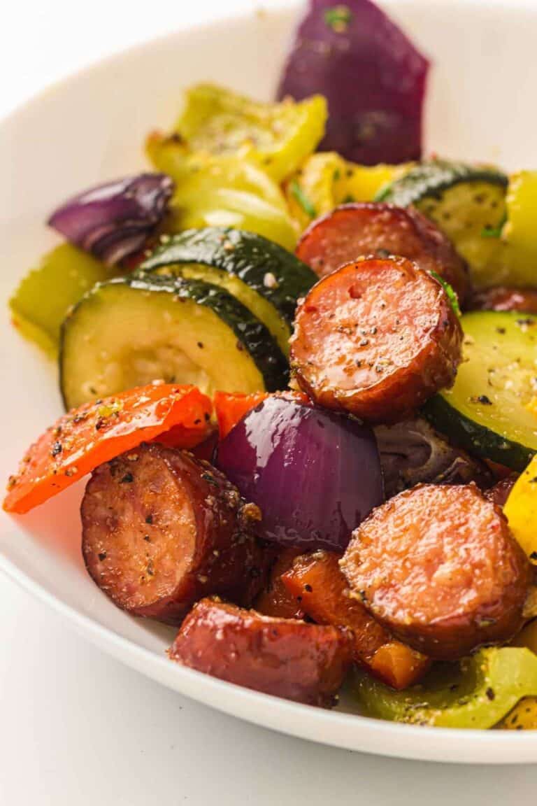 A white bowl filled with Sheet Pan Sausage & Roasted Vegetables.