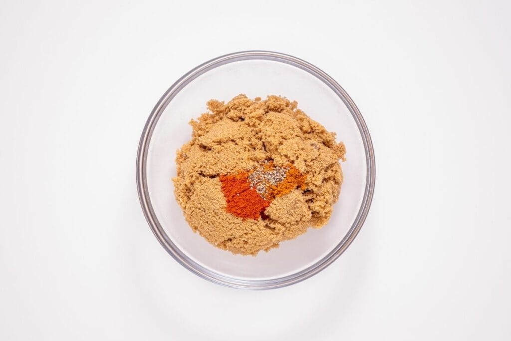 Brown sugar, cayenne pepper, paprika, and black pepper mixed together in a bowl.