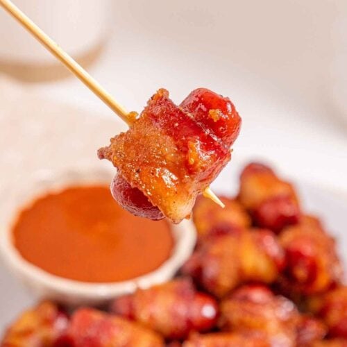 Delicious bacon-wrapped sausage bites with savory sauce, ideal party appetizer, easy to make.