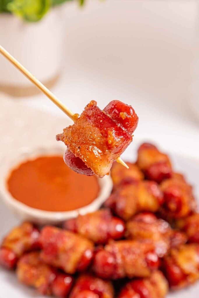 Delicious bacon-wrapped sausage bites with savory sauce, ideal party appetizer, easy to make.