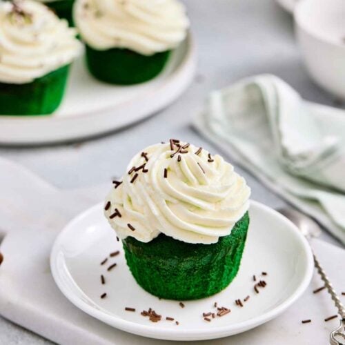 Delicious green matcha cupcake topped with creamy white frosting and chocolate sprinkles.