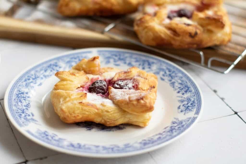 A plate of a Danish Pastries with Cream Cheese & Cherries.