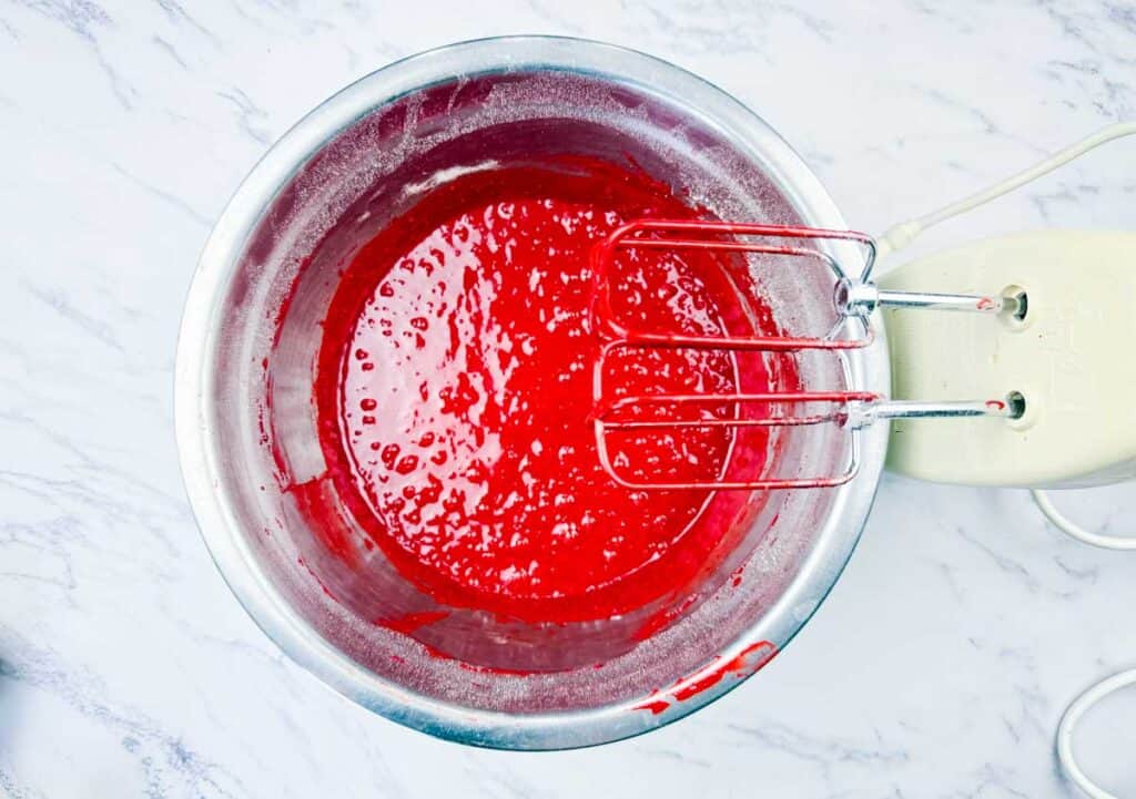 Cake mix and cake mix ing mixed together using a hand mixer.