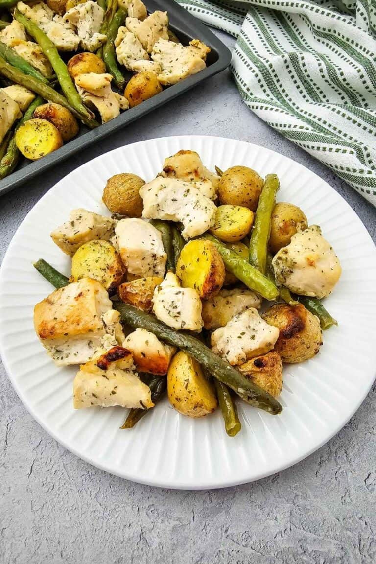 Healthy food with chicken, potatoes, and green beans on a white plate.