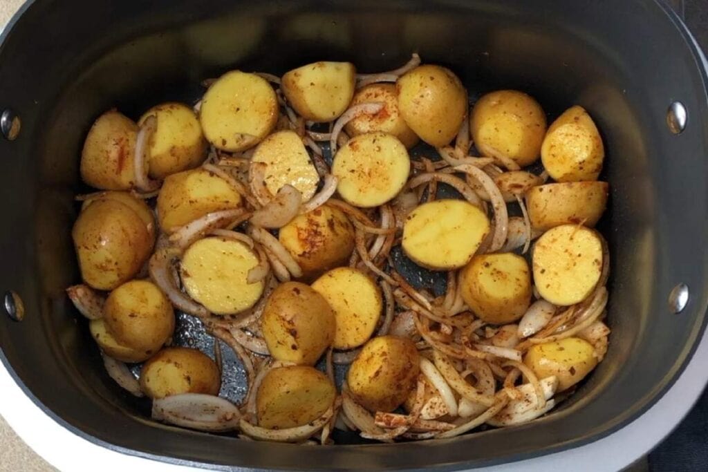 Air fryer mini potatoes with onions and seasoning for easy, healthy cooking.