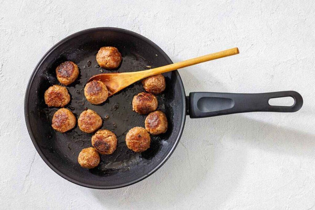 Brown the meatballs in the skillet.