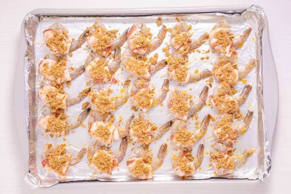 Shrimp wrapped with bacon and sprinkled with brown sugar.