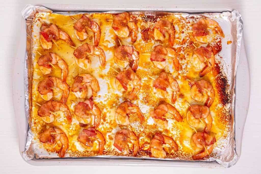 Fresh shrimp pizza with melted cheese and crispy crust on baking sheet.