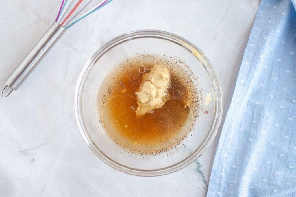 Whisk together the pineapple juice, Dijon mustard, brown sugar, apple cider vinegar, melted butter, black pepper, and ground cloves.