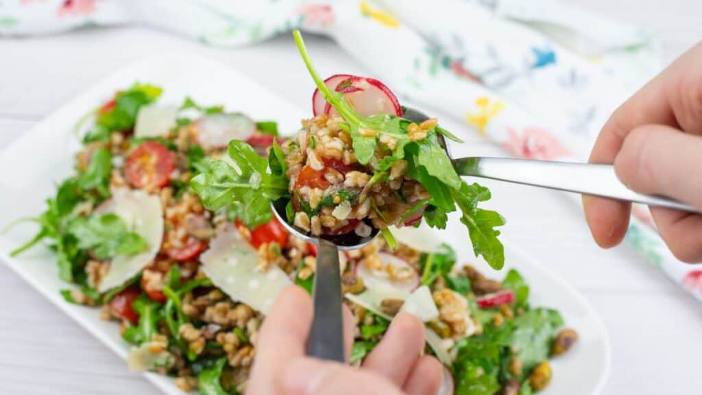 A spoonful of Copycat Charlie Bird’s Farro Salad from the white plate.