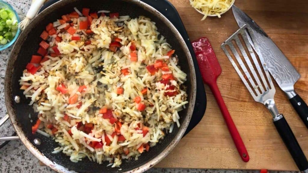 Push the hash browns aside and add the diced onion and bell pepper