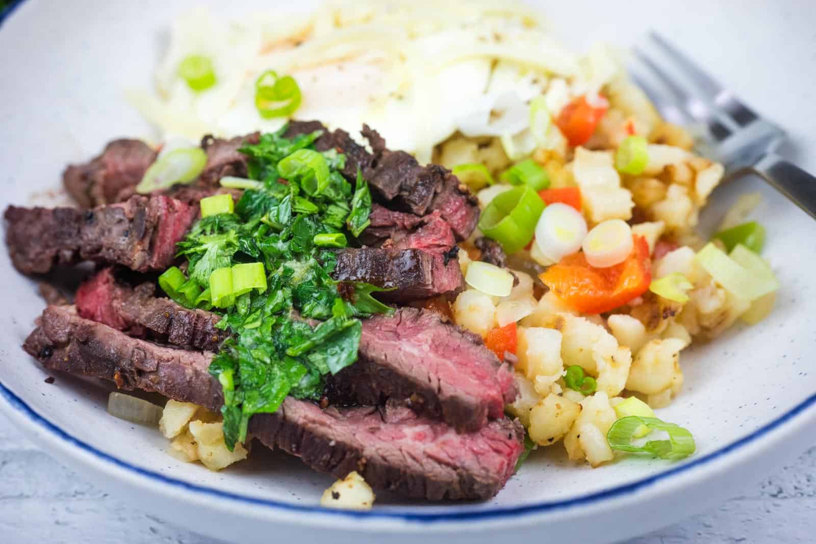 Close-up shot of Steak and Eggs Breakfast Bowl on a plate.