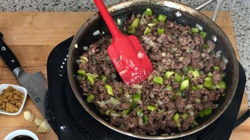 Brown the ground beef and add the diced onion and green bell pepper to the same skillet.