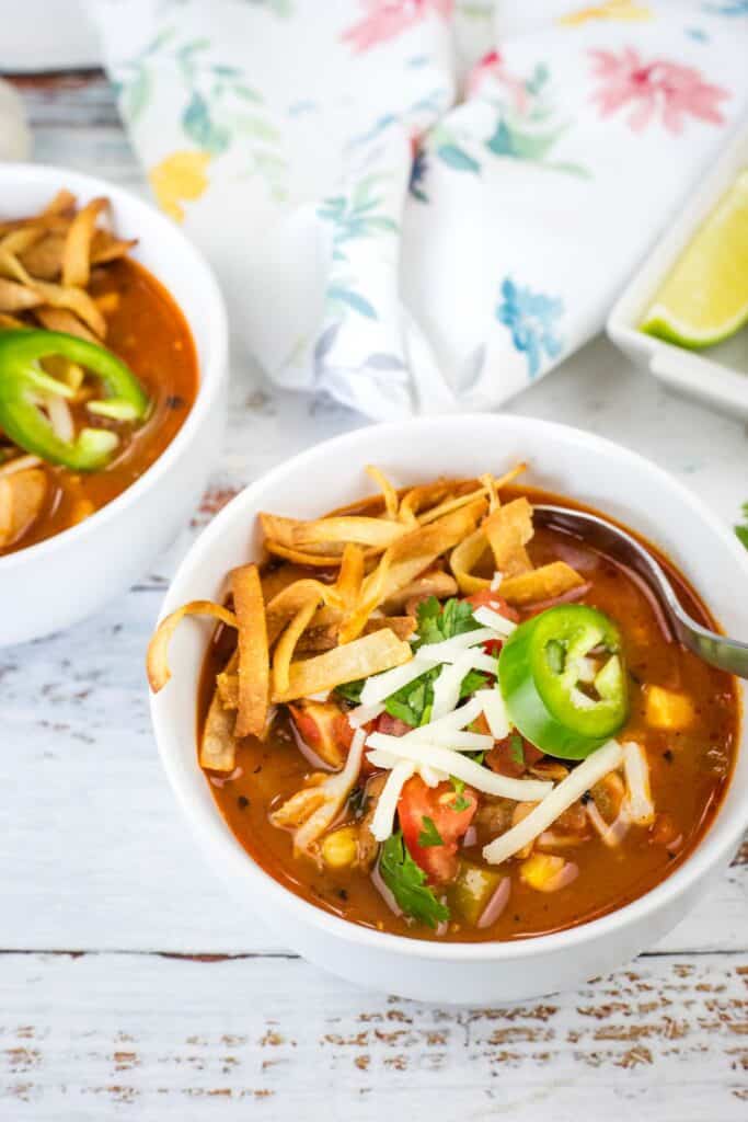 A white bowl fills with a Chicken Tortilla Soup.